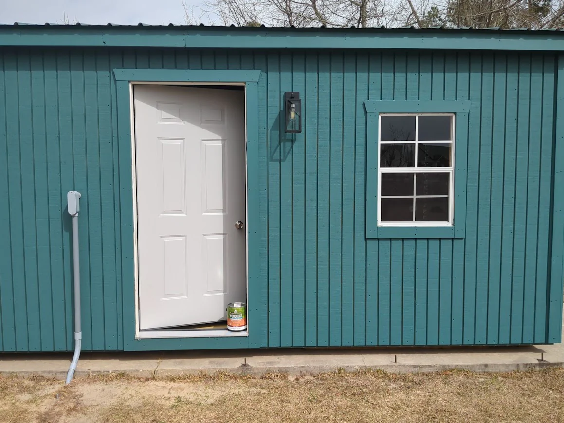 Teal metal building with a new white door and window