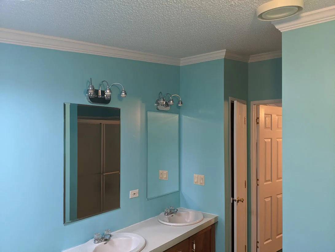 Bathroom with a double vanity, mirrors, and freshly painted walls