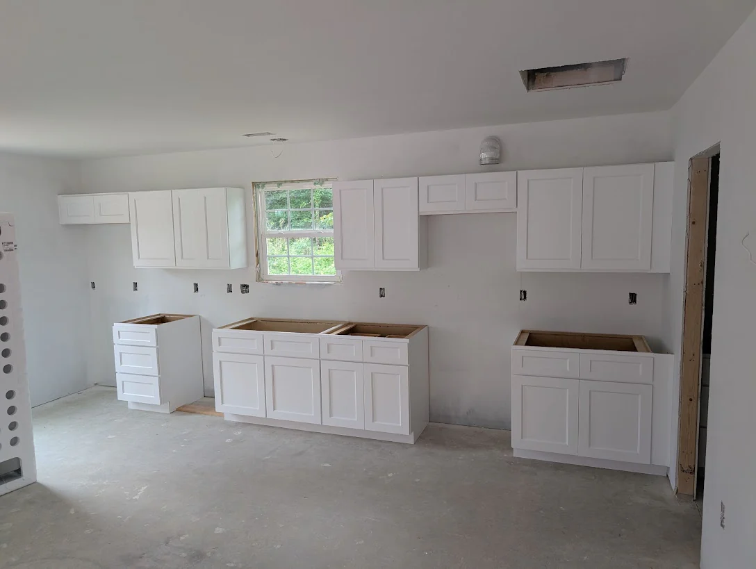 Kitchen remodel with white cabinets installed and countertops still open